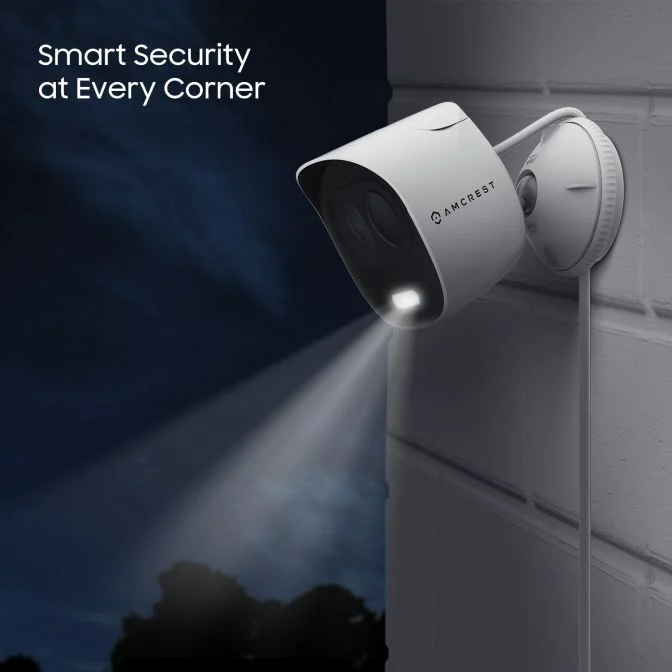 Wall-mounted security camera illuminating a dark area.