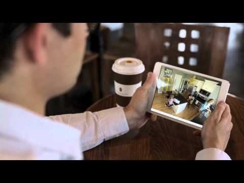 Person viewing a cafe scene on a tablet while holding a coffee cup.